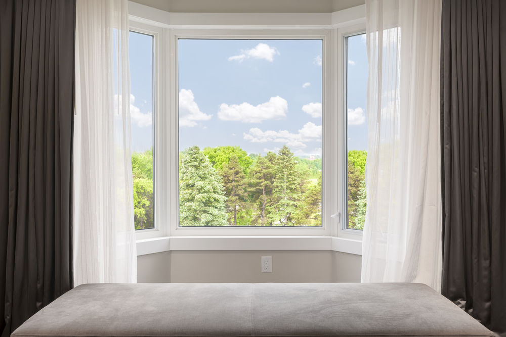 Bay,Window,With,Drapes,,Curtains,And,View,Of,Trees,Under